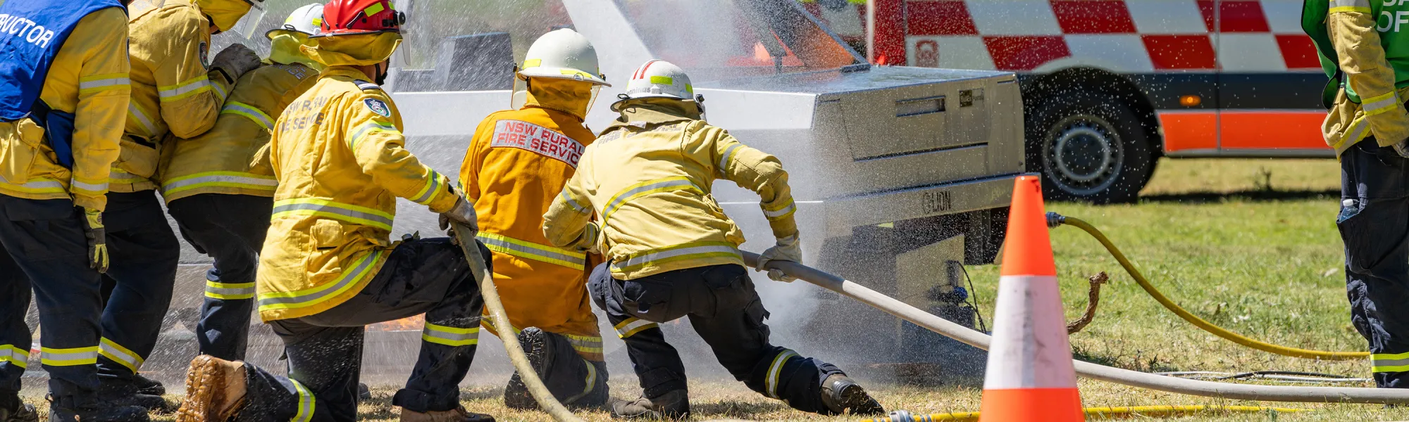 Emergency service workers fighting a car fire
